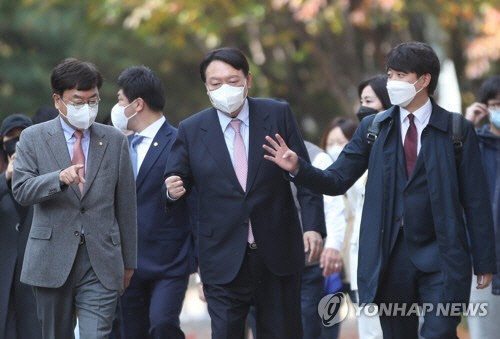 국민의힘 이준석 대표가 6일 오후 윤석열 대선 후보와 오찬을 위해 서울 마포구 염리동 한 식당으로 대화하며 이동하던 중 손가락 네 개를 펴 보이자 윤 후보가 주먹을 쥐고 있다. 앞줄 왼쪽은 서범수 의원.  연합뉴스